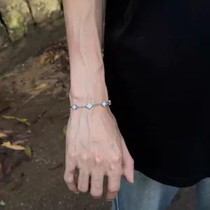 Silver titanium steel cross bracelet shown on male wrist with multiple charms