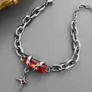 Détail de chaîne hip hop avec une grande pierre rouge rectangulaire et un pendentif étoile