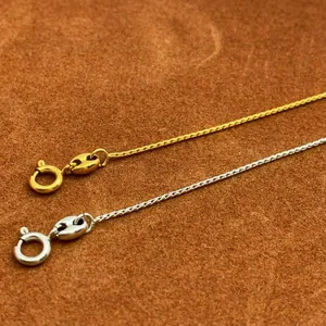 Close-up of gold and silver needle-style adjustable chains with spring clasp detail