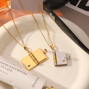 Detail of heart-shaped opening book locket pendant necklace in gold and silver finish