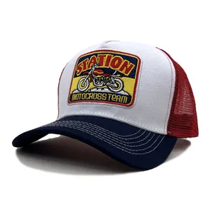 Détail de la broderie moto rétro sur casquette trucker en mesh rouge et blanc aéré