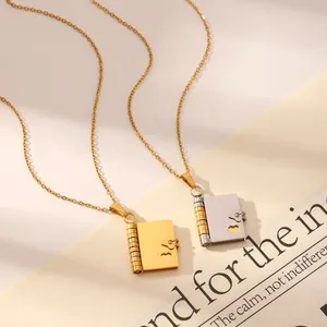 Macro shot of gold heart book locket necklaces with detailed loose-leaf ring binding texture