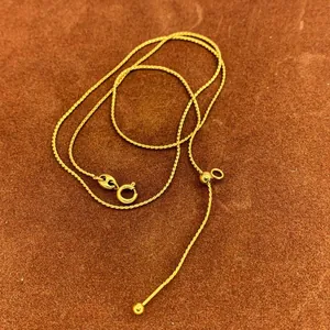 Detailed view of adjustable 18K gold twisted chain necklace with spring ring clasp