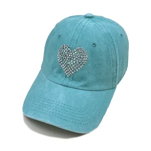 Detailed view of lake blue washed denim baseball cap with sparkling rhinestone heart motif