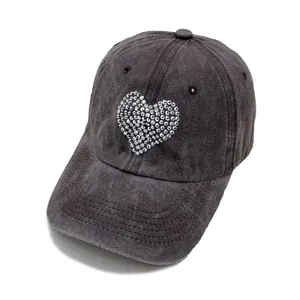 Detailed view of dark grey washed denim baseball cap with heart rhinestone embellishment