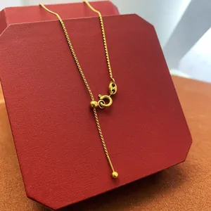 Detail of adjustable 18K gold plated slider bead chain on a red jewelry box