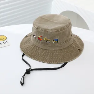 Dettaglio cappello a secchiello per bambini in cotone lavato con ricamo veicoli da cantiere