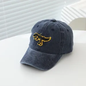Gros plan détaillé sur la broderie de dinosaure jaune d'une casquette bleue délavée