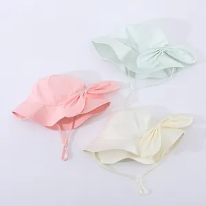 Detail of baby sun hats in pink, mint, and cream with large bows and adjustable chin straps