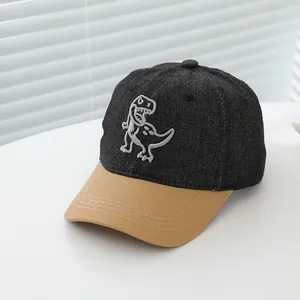 Close-up of T-Rex embroidery on kids denim baseball cap with khaki brim detail