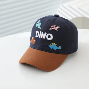 Detailed close-up of a kids' navy baseball cap featuring 3D DINO embroidery and colorful patches