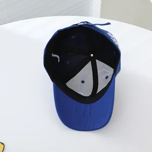 Dettaglio dell'interno del cappellino blu con cuciture e fibbia in metallo regolabile