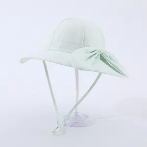 Close-up of mint green kids sun hat with wide brim, large bow, and adjustable chin strap