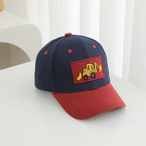 Detail of navy blue kids baseball cap featuring red brim and yellow excavator embroidery