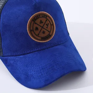 Navy blue faux suede trucker hat with mesh back and circular leather outdoor patch