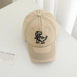 Beige baseball cap for boys featuring black dinosaur embroidery and contrast stitching