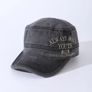 Detail of charcoal grey military cap with white Youth 1995 embroidery on washed canvas