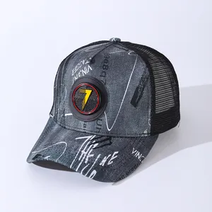 Detail of grey denim trucker hat with white graffiti print and yellow number 7 badge