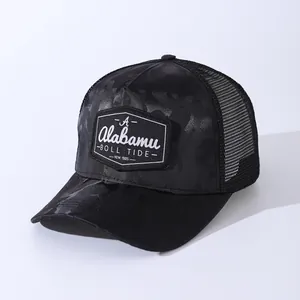 Detail of black camo trucker hat featuring a shield patch with A Alabamu Roll Tide 1985 text