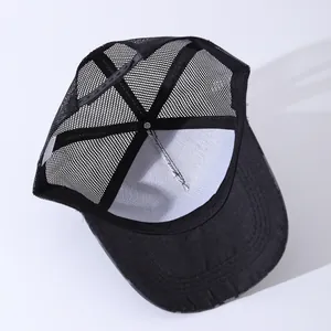 Detail view of the breathable mesh back and adjustable strap on the black trucker hat