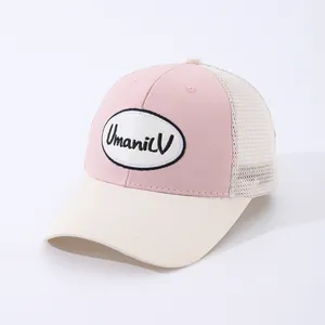 Pink and cream mesh trucker hat with Umani V embroidery patch and curved brim