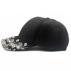Détail de la casquette snapback hip-hop noire avec imprimé paisley blanc sur le bord plat