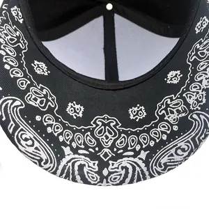 Détail de la visière plate du chapeau hip-hop avec motif paisley blanc sur coton noir
