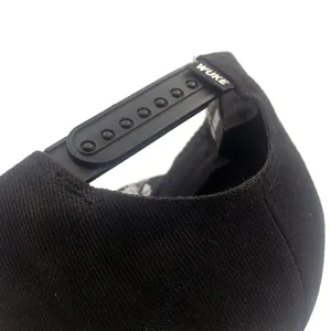 Détail d'une casquette snapback noire en coton avec sangle de réglage et imprimé