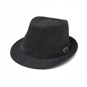 Détail d'un chapeau de paille noir avec texture tressée et boucle de ceinture en cuir