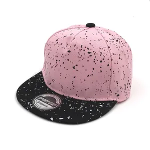 Detail of pink and black snapback hat with ink splatter pattern and cotton twill texture