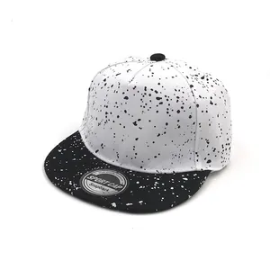 Detail of kids snapback hat with black and white ink splatter pattern and flat brim
