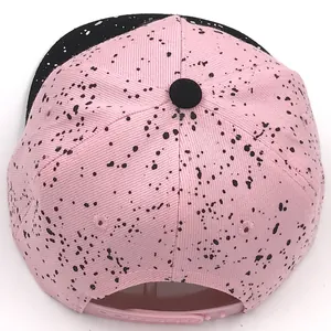 Pink adjustable kids snapback hat with black splatter pattern and plastic back closure