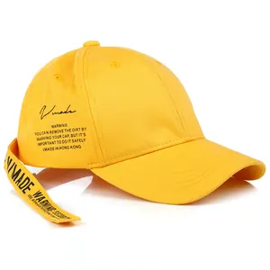 Dettaglio del cappellino da baseball giallo con lunga cinghia decorativa e logo Vmade