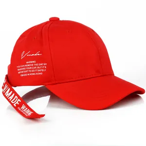 Dettaglio del cappellino rosso con lunga cinghia VMADE WARNING e scritte laterali