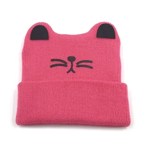 Detailed knit texture of pink baby beanie with cat ears and embroidered whiskers