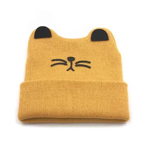Bright yellow knit baby beanie featuring cute black cat ears and whiskers design