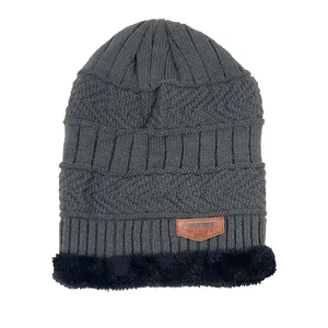Detalle del gorro de punto con forro polar grueso y etiqueta decorativa de cuero marrón