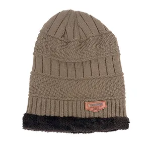 Detalle de gorro de punto de invierno con forro polar suave y logo de parche de cuero