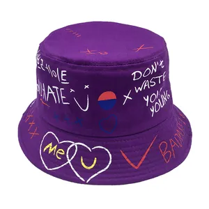 Detail of purple cotton bucket hat featuring street style graffiti and white heart print