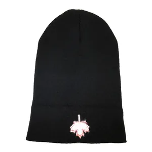 Black knit beanie with white and red Canadian maple leaf embroidery on the folded cuff