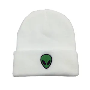 Détail de la broderie alien verte sur un bonnet blanc en tricot à côtes fines