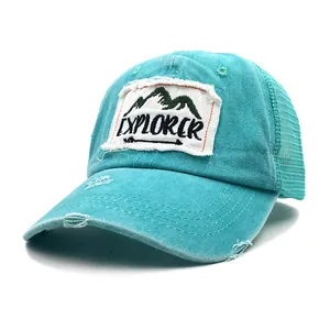 Detail of turquoise trucker hat with Explorer mountain patch and distressed washed cotton fabric