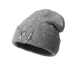 Detailed texture of grey ribbed knit beanie with punk silver chains and butterfly charms