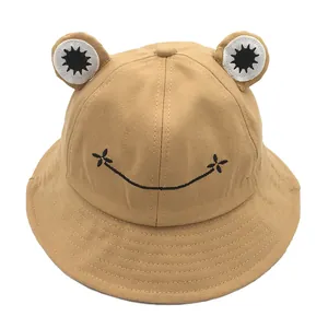 Close-up of khaki frog bucket hat showing embroidered smile and 3D eye details