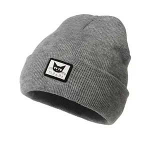 Dettaglio di un berretto in maglia a coste grigio chiaro con patch di un gatto nero