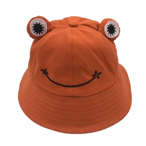 Detail of a bright orange frog bucket hat with 3D eyes and reinforced brim stitching
