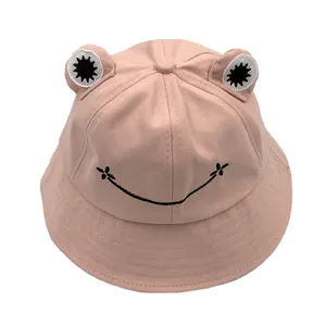 Close-up of pink frog bucket hat with 3D embroidered eyes and smiling face design
