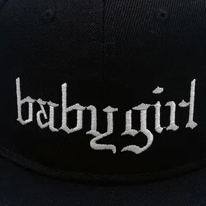 Black cotton flat brim hat featuring white gothic babygirl embroidery detail