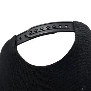 Dettaglio chiusura snapback regolabile su cappellino baseball nero ricamato cielo stellato