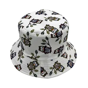 Detail of white bucket hat featuring cute cartoon owl patterns and reinforced stitching